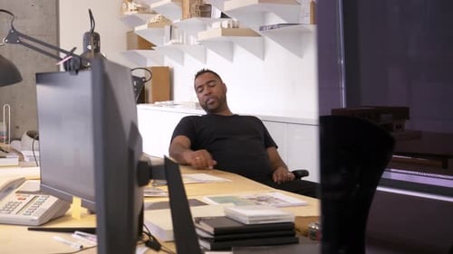 Man Seated at Desk in Modern Office Setting