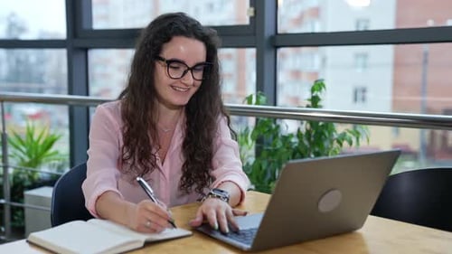 Businesswoman in glasses working. Young pretty business lady working with computer.