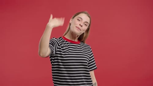 Smiling Woman Waving on Red Background