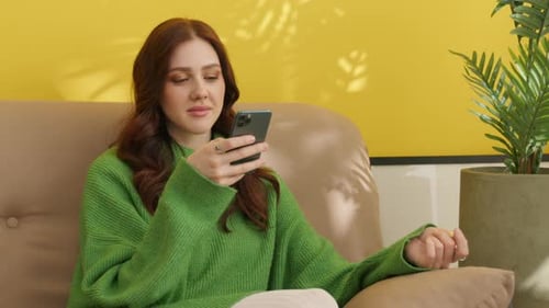 Woman Using Smartphone while Relaxing on Couch