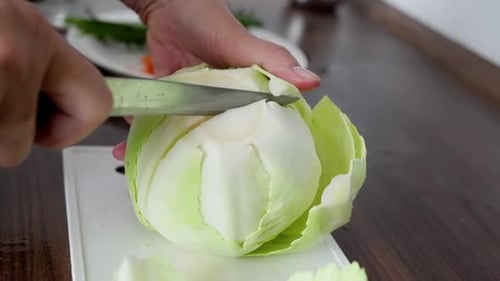 Beobachten Sie, wie frischer Kohl mit einem scharfen Messer fein gehackt wird — für leckere und gesunde Rezepte