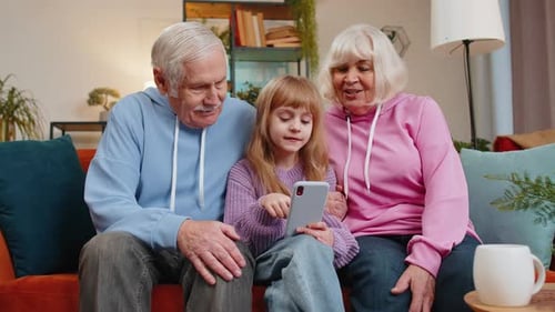 Girl Using Phone with Grandparents on Couch