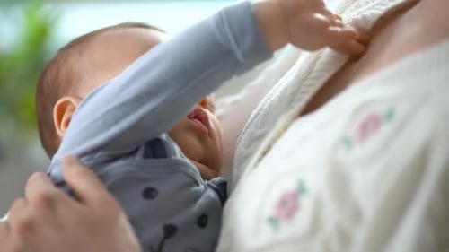 Infant Sleeping Soundly in Mother's Arms Close Up