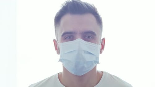 Young Adult Removes Surgical Mask Indoors