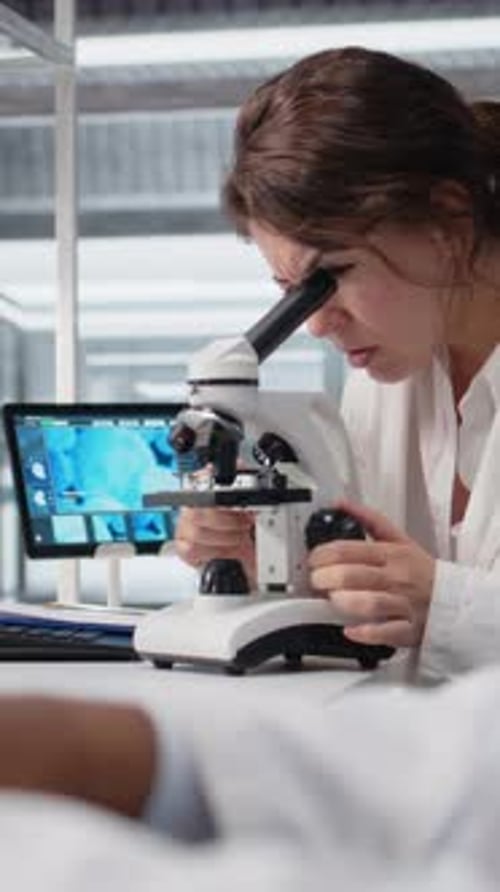 Woman Scientist Using Microscope in Lab Research