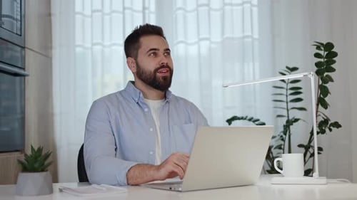 Man Working on Laptop at Desk Indoors