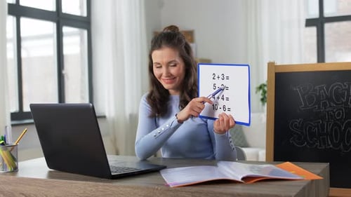 Woman teaching math online with board and laptop