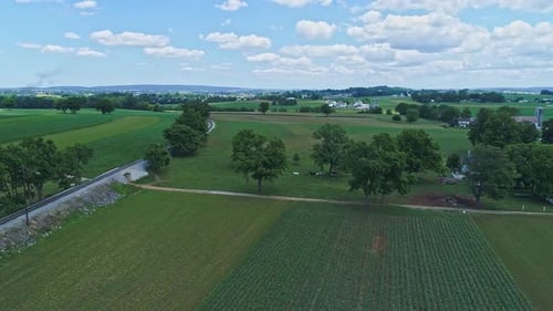 An Aerial View of the Farm Countryside With Planted Fields and a Single Rail Road Track on a Curve o