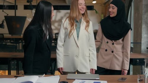 Diverse Women Give Thumbs Up in Modern Office