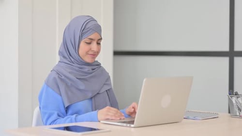 Woman in Hijab Working on Laptop at Desk