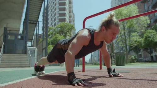 Sportive Man Performing Push Ups at Outdoor Gym