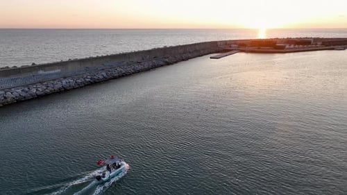 Small Fishing Boat Slowly Motoring Along Coast at Golden Hour Aerial View