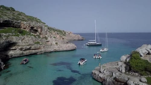 A Drone Rises Over a Bay in Mallorca with Boats and Shows the Skyline