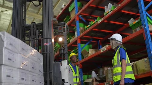 Warehouse worker controlling boxes in warehouse, Professional male warehouse worker moving cardboard