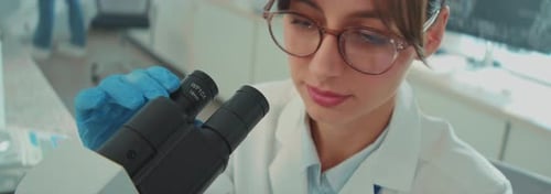 Female Scientist Using Microscope in Medical Laboratory