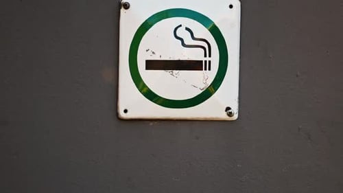 Capturing a Slow Motion Closeup Video of a Smoking Area Sign Intended for Designated Smokers in a