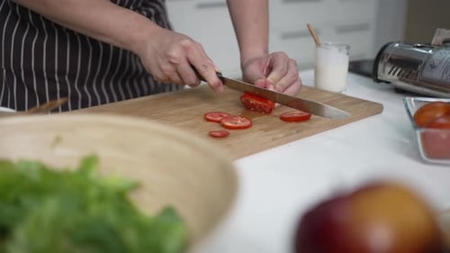 Adult Slicing Tomatoes in Bright Kitchen