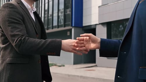 Two Business Man Shaking Hands Hitting Fist Friendly Informal Greeting Outdoor Office Building
