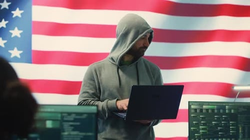 Man Typing on Laptop With US Flag