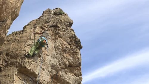 A Man is Climbing a Rock Wall