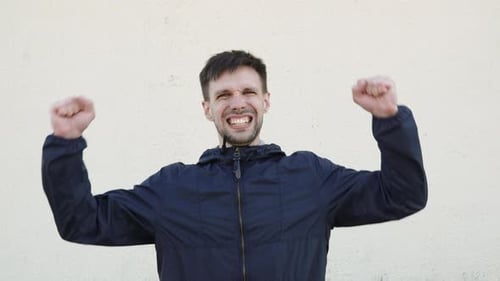Caucasian Man Rejoices and Exults Gesturing with Hands Looking at Camera