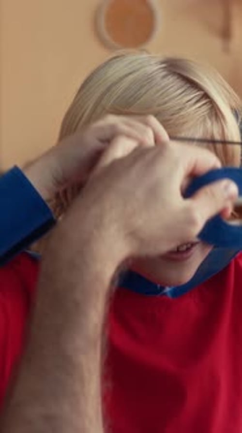 Boy Gets Superhero Mask from Adult Inside Home
