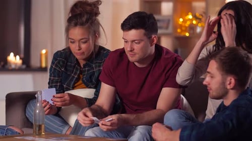 Group of friends playing cards on living room floor