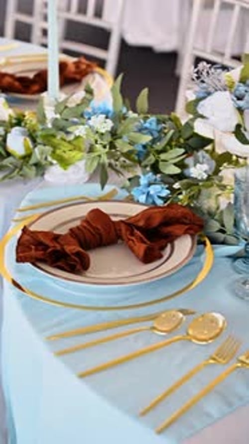 Top view of gold cutlery and blue table decor. Overhead shot of gold forks, spoons