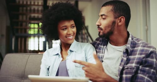 Woman and Man Using Tablet Together on Couch