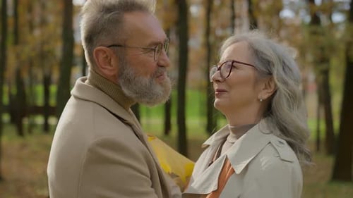 Mature Couple Embracing in Autumn Park