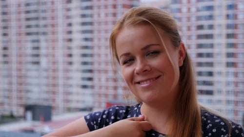 A Woman with the Keys to a New Apartment on the Balcony of a Residential Complex