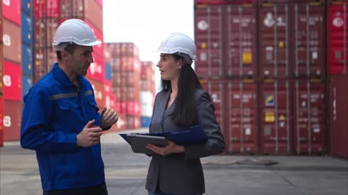 Container manufacturing manager and businesswomen survey the area to plan the storage