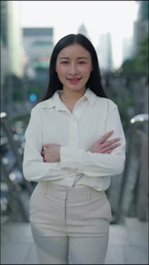 Vertical Video Asian Woman Standing Outside and Posing with Hands in Stylish Office Attire