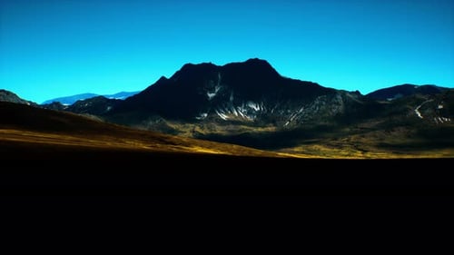 Majestic Mountain Silhouette Under a Clear Blue Sky at Dusk