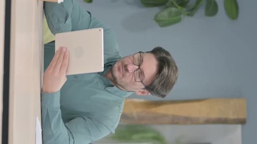 Vertical Video of Man using Digital Tablet, Browsing Internet