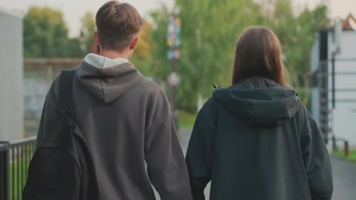 Youthful Outdoor Stroll Group of Teens Walking on Scenic Trail Amid Trees Two Young Individuals
