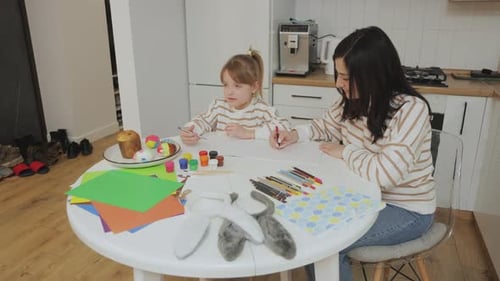 Woman and Child Drawing at Kitchen Table for Easter