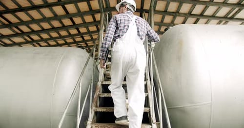 Un vigneron masculin vérifie la qualité du processus de distillation des boissons à l'intérieur