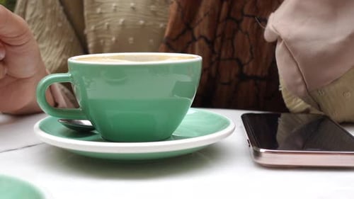 Frauen halten eine Kaffeetasse