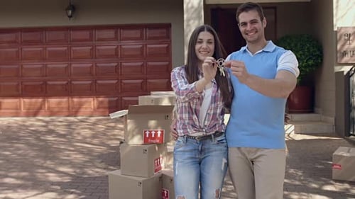 Happy Couple Holding Keys in Front of New Home