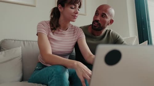 Woman and Man Use Laptop Together at Home