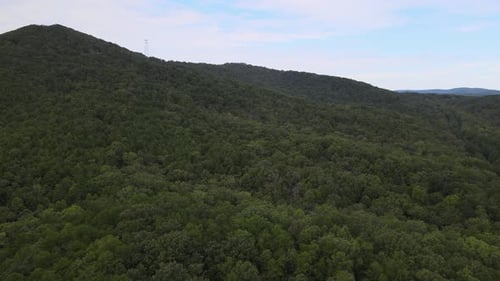 Montagnes couvertes d'arbres avec une tour en arrière-plan
