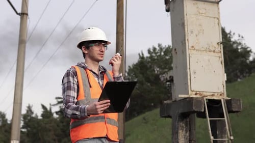 Railway engineer speaks on the radio walkie-talkie. The railroad is a critical infrastructure.