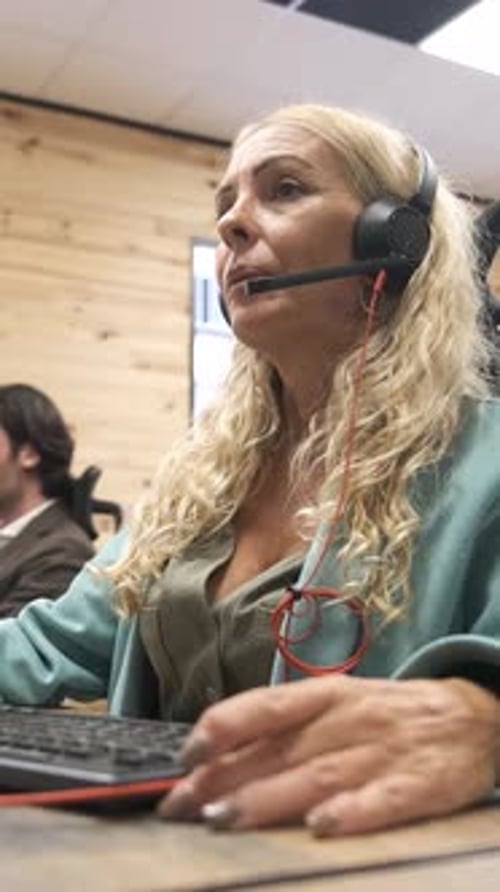 Woman With Headset Working at Computer in Office
