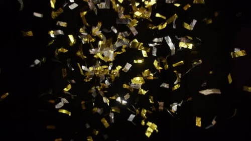 Gold and Silver Confetti Falling on Black Background
