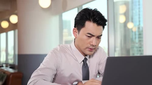 Porträt eines konzentrierten, vielbeschäftigten jungen Geschäftsmannes, der auf dem Laptop tippt, online arbeitet und Notizen aus der Ferne schreibt i