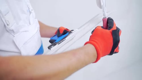 Close-up hand builder worker puts plaster on a spatula or trowel. Construction Worker Gypsum Plaster