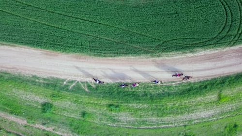 Horseback riding in a green Badlands terrain, aerial footage