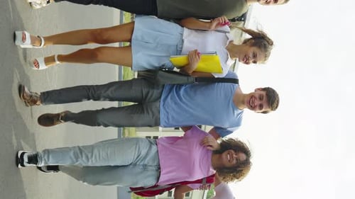 Vertical Screen Multiethnic Friends Walking Together Against College Building