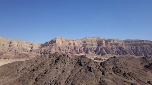 Empty desert road with mountains and blue sky in the background